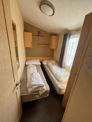 a small room with two beds and a window at Singh&Leite Family L6 in Saint Osyth