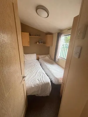 a small room with two beds and a window at Singh&Leite Family L6 in Saint Osyth