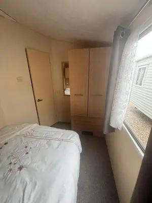 a small bedroom with a bed and a window at Singh&Leite Family L6 in Saint Osyth