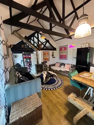 a living room with a blue couch and a table at Goldings detached Barn farm stay in Hertford