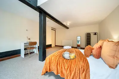 a bedroom with a bed with an orange blanket at 4 Bdr House with TV, Wifi, near Thetford town in Thetford