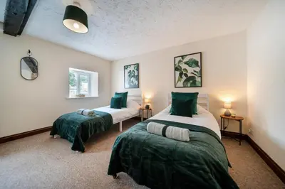 a bedroom with two beds with green pillows at 4 Bdr House with TV, Wifi, near Thetford town in Thetford
