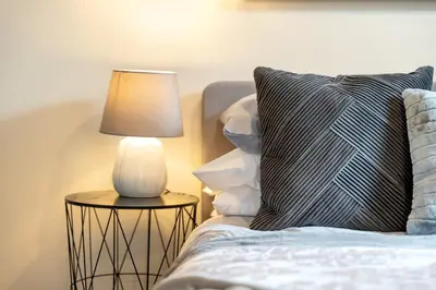 a lamp on a side table next to a bed at 4 Bdr House with TV, Wifi, near Thetford town in Thetford