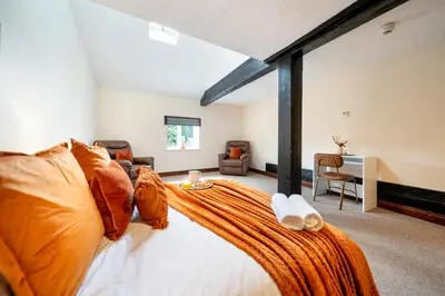 a bedroom with a large bed with an orange blanket at 4 Bdr House with TV, Wifi, near Thetford town in Thetford