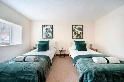 two beds in a room with green and white at 4 Bdr House with TV, Wifi, near Thetford town in Thetford