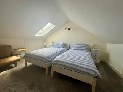 a bedroom with two beds and a skylight at Southend city Escape, SS1, High St and beach are steps away in Southend-on-Sea