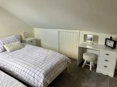 a bedroom with a bed and a desk and a chair at Southend city Escape, SS1, High St and beach are steps away in Southend-on-Sea