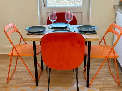 a dining room table with four chairs and wine glasses at Southend city Escape, SS1, High St and beach are steps away in Southend-on-Sea