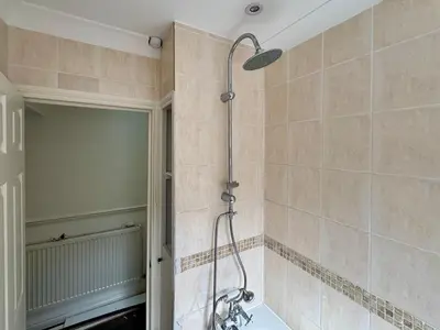 a shower in a bathroom with a tiled wall at Southend city Escape, SS1, High St and beach are steps away in Southend-on-Sea