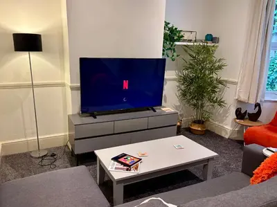 a living room with a flat screen tv on a dresser at Southend city Escape, SS1, High St and beach are steps away in Southend-on-Sea