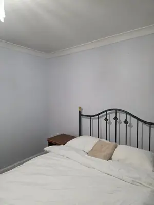 a bedroom with a bed with white sheets and a table at Essex studio x2 in Hythe