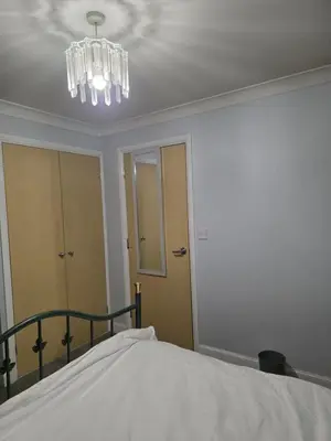 a bedroom with a bed and a chandelier at Essex studio x2 in Hythe
