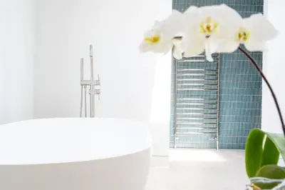 a bathroom with a view of the shard and white flowers at Heath House 8 in Thorpeness