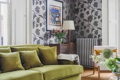 a green couch in a living room with wallpaper at 6 Bedroom - Luxury - Cinema Room in Hertford