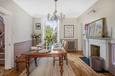 a dining room with a table and a fireplace at 6 Bedroom - Luxury - Cinema Room in Hertford