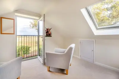 a room with a white chair and a window at 5 Bed in Washbrook oc-m33105 in Hintlesham