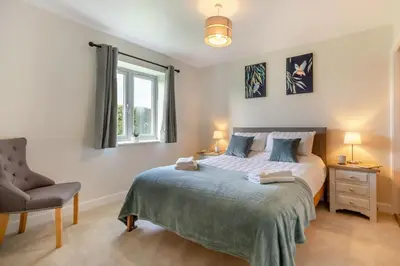 a bedroom with a bed and a chair and a window at 5 Bed in Washbrook oc-m33105 in Hintlesham