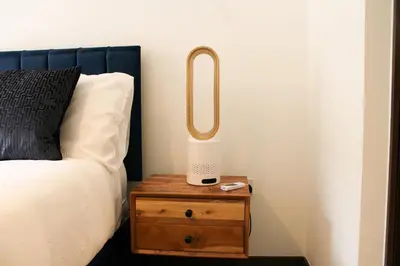 a bedroom with a bed and a table with a lamp at Stylish Essex Apartment, Balcony & Scenic Views in Harlow