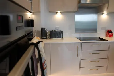 a kitchen with white cabinets and a counter top at Stylish Essex Apartment, Balcony & Scenic Views in Harlow