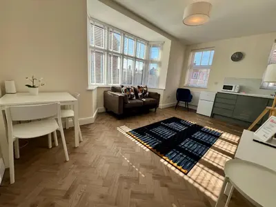 a living room with a couch and a table at 1 The Royal Serviced Apartments, Harwich SuperKing Bed, Parking, Fast WiFi in Parkeston