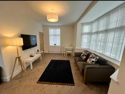 a living room with a couch and a tv at 1 The Royal Serviced Apartments, Harwich SuperKing Bed, Parking, Fast WiFi in Parkeston