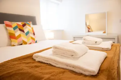 two stacks of towels sitting on top of a bed at 1 The Royal Serviced Apartments, Harwich SuperKing Bed, Parking, Fast WiFi in Parkeston