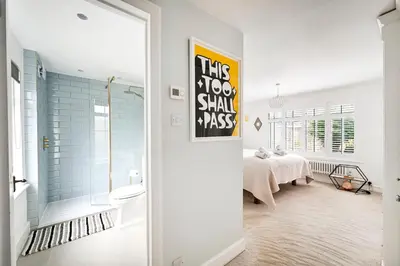 a bedroom with a bed and a bathroom with a tub at Stylish 3-Bed Home Close to Stansted Airport in Stansted Mountfitchet
