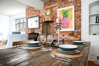 a dining room with a wooden table with wine glasses at Stylish 3-Bed Home Close to Stansted Airport in Stansted Mountfitchet