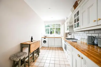 a kitchen with white cabinets and a counter top at Stylish 3-Bed Home Close to Stansted Airport in Stansted Mountfitchet