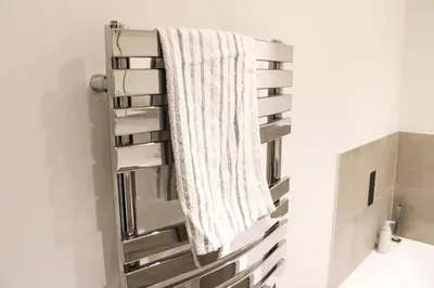 a towel hanging on a towel rack in a bathroom at The Ivy Abode, Stylish 2-Bed Apartment Free Parking in Harlow