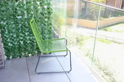 a green chair sitting in front of a green wall at The Ivy Abode, Stylish 2-Bed Apartment Free Parking in Harlow