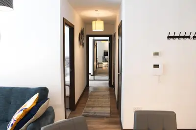 a living room with a blue couch and a hallway at The Ivy Abode, Stylish 2-Bed Apartment Free Parking in Harlow