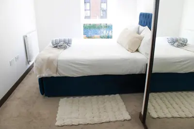 a bedroom with two beds and a mirror at The Ivy Abode, Stylish 2-Bed Apartment Free Parking in Harlow