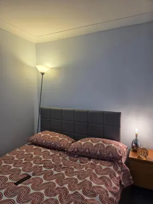 a bedroom with a bed with a lamp on it at Essex desk chair Free parking WiFi x3 in Hythe