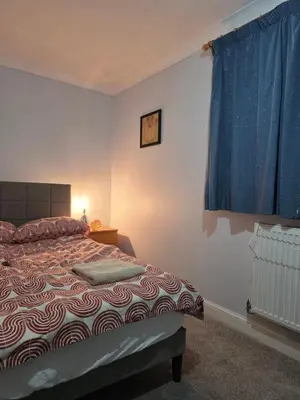 a bedroom with a bed and a blue curtain at Essex desk chair Free parking WiFi x3 in Hythe