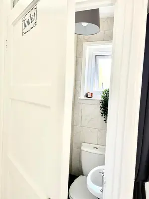 a bathroom with a white toilet and a window at Spacious 4-Bed Home Near Cambridge City Centre in Chesterton