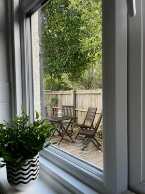 a window view of a patio with two chairs and a table at Spacious 4-Bed Home Near Cambridge City Centre in Chesterton