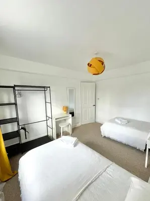 a white room with two beds and a desk at Spacious 4-Bed Home Near Cambridge City Centre in Chesterton
