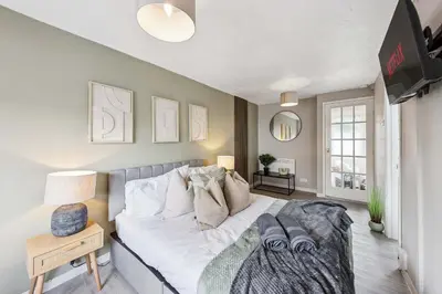 a bedroom with a large white bed in a room at 3Bed, Sleeps 7, TV in Each Room, Garden, Parking in Basildon
