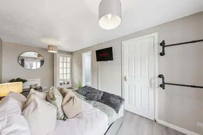 a bedroom with a bed and a tv on a wall at 3Bed, Sleeps 7, TV in Each Room, Garden, Parking in Basildon