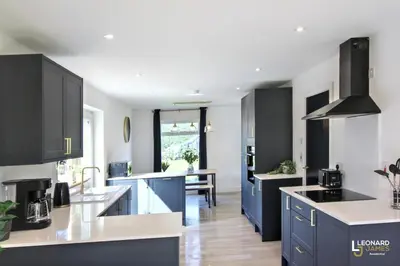 a kitchen with blue cabinets and a dining room at Bright & Stylish Bungalow Retreat in Attleborough in Attleborough