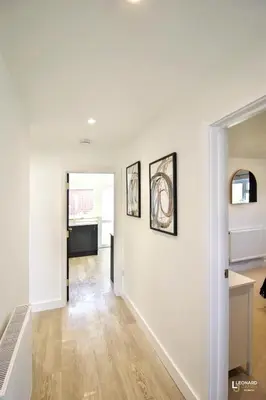 a hallway of a home with white walls and wood floors at Bright & Stylish Bungalow Retreat in Attleborough in Attleborough