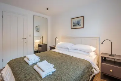 a bedroom with a large bed with towels on it at 1 Leiston Court, Leiston in Leiston