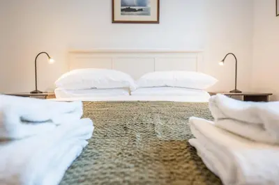 a bedroom with two beds with white pillows at 1 Leiston Court, Leiston in Leiston