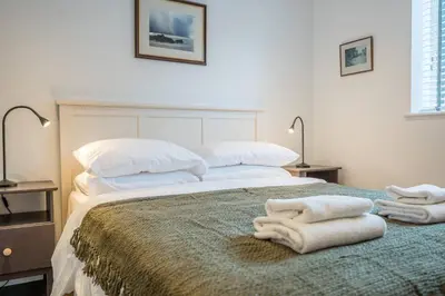 a bedroom with a large bed with towels on it at 1 Leiston Court, Leiston in Leiston