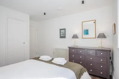 a bedroom with a bed and a dresser and a mirror at 1 Leiston Court, Leiston in Leiston