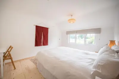 a white bedroom with a large bed and a window at The Bantams, Monk Soham in Bedfield