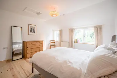 a bedroom with a bed and a dresser and a mirror at The Bantams, Monk Soham in Bedfield