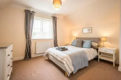 a bedroom with a large bed and a window at Cosy 4BR Cottage in Great Glemham Village in Great Glemham