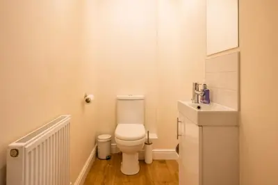 a white bathroom with a toilet and a sink at Cosy 4BR Cottage in Great Glemham Village in Great Glemham
